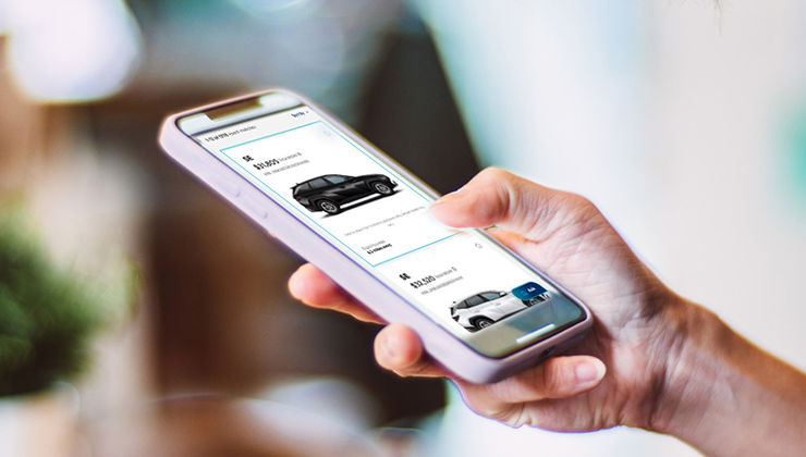 Person browsing vehicle listings on a mobile phone.