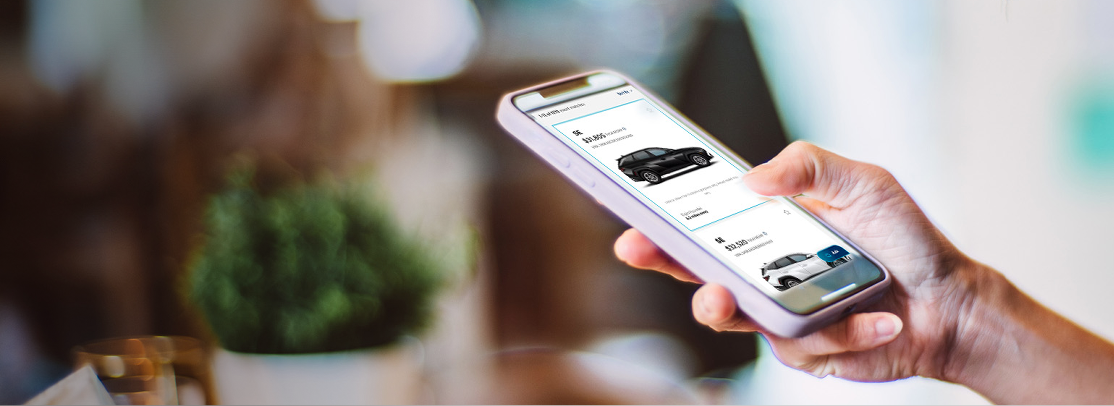 Person browsing vehicle listings on a mobile phone.
