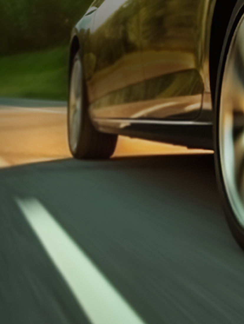 Close-up of car tire driving on open road.